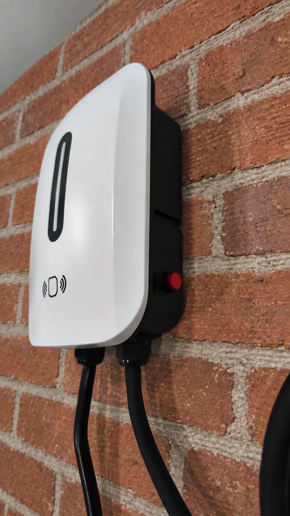 Cargador Bora blanco instalado en una pared de ladrillo